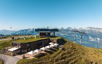 Ein Berggasthaus von oben fotografiert vor einer Bergkulisse | © Bergbahnen Flumserberg AG