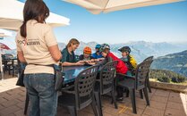 Serviceangestellte nimmt Bestellung an einem Tisch mit fünf Biker auf | © Bergbahnen Flumserberg AG