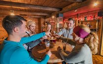 Freundesgruppe stösst in einer Berghütte miteinander an | © Bergbahnen Flumserberg AG
