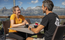 Eine Frau und ein Mann geniessen einen Kaffee auf der Terrasse einer Berghütte mit Aussicht auf die Churfirsten | © Bergbahnen Flumserberg AG