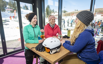 Drei junge Frauen sitzen in Skikleidung bei einem Aperitif zusammen | © Bergbahnen Flumserberg AG