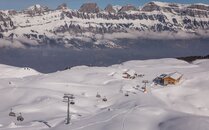 Sesselbahn mit einer Berghütte und den Churfirsten im Hintergrund im Winter | © Bergbahnen Flumserberg AG