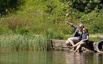 Eine Frau und ein Mädchen sitzen gemeinsam an einem See und schauen in die Ferne | © Bergbahnen Flumserberg AG
