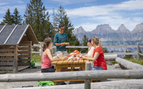 Vier Erwachsene sitzen an einem Holztisch beim Grillen | © Bergbahnen Flumserberg AG