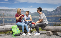 Zwei Frauen und ein Junge sitzen gemeinsam an einer Feuerstelle | © Bergbahnen Flumserberg AG