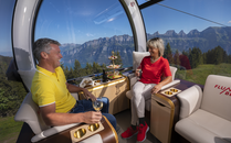 Paar geniesst Wein und Häppchen in einer luxuriösen Gondel mit Bergpanorama | © Bergbahnen Flumserberg AG