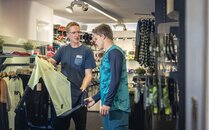 Mitarbeiter berät einen Kunden beim Kauf von Bikeausrüstung | © Bergbahnen Flumserberg AG