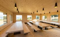 Hölzener Aufenthaltsraum mit mehreren Bänken und Stühlen | © Bergbahnen Flumserberg AG