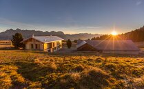 Zwei Berghütten stehen nebeneinander mit einem Sonnenuntergang im Hintergrund | © Bergbahnen Flumserberg AG