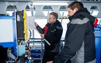 Zwei Techniker diskutieren einen technischen Plan in der Seilbahnkabine | © Bergbahnen Flumserberg AG