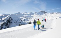Familie am Wandern auf Winterweg mit einem Schlitten | © Bergbahnen Flumserberg AG