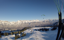Verschneite Winterlandschaft mit einem Gleitschirmflieger in der Luft | © Bergbahnen Flumserberg AG